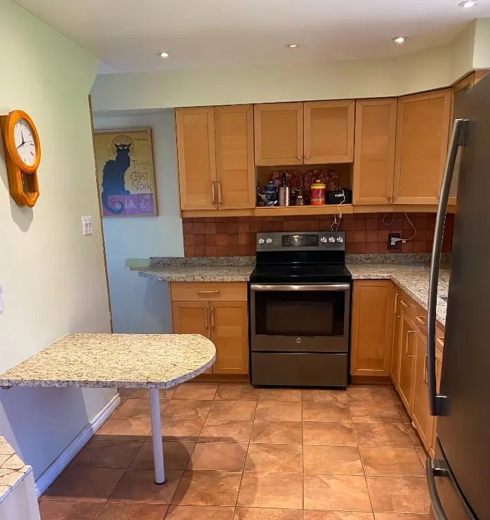After: the same kitchen with speckled stone countertops and breakfast bar